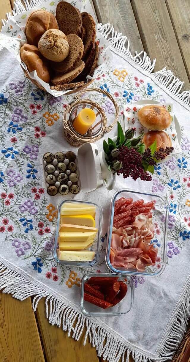 Weinviertler Picknick mit Hund. Bio Wurst und Käse, Eier, Gebäck auf einem Tisch.
